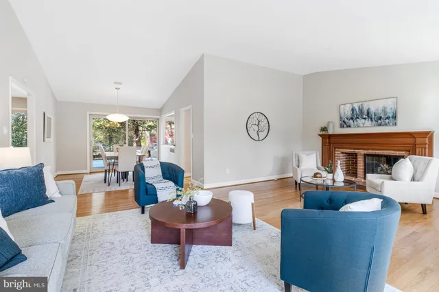 a kitchen with granite countertop a refrigerator a sink dishwasher a stove and white cabinets with wooden floor