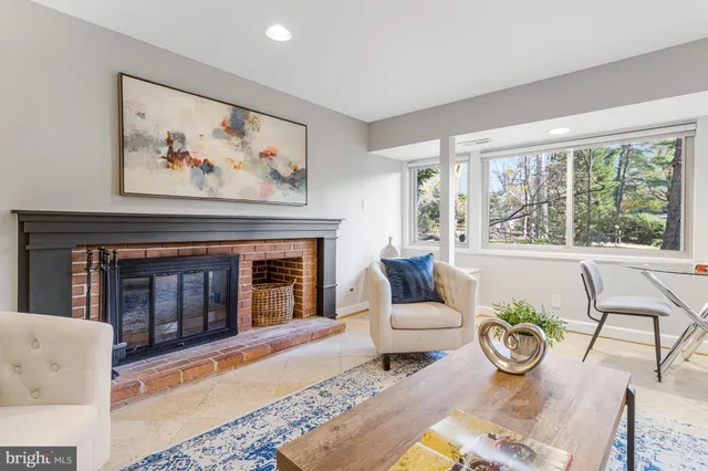 a bedroom with a bed and a lamp on dresser next to a window