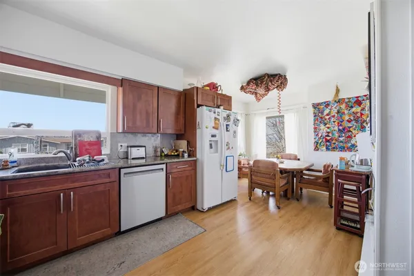 a kitchen with stainless steel appliances wooden floor and a refrigerator