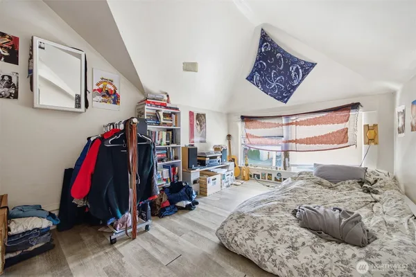 a bedroom with a bed a standing and a window