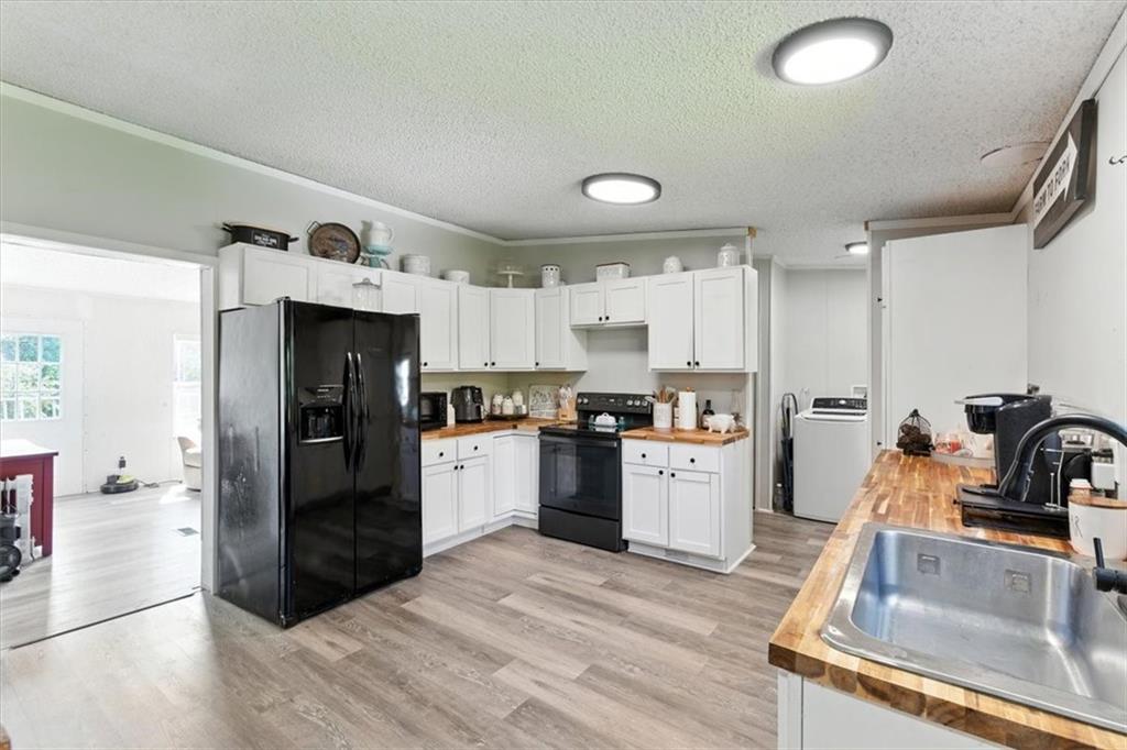 71 Kirk Road Northwest White, GA 30184 - Photo 43 of 74 a kitchen with a refrigerator a sink and white cabinets