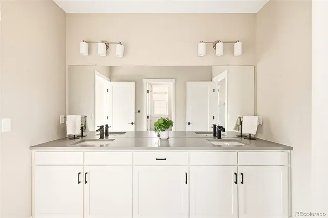a bathroom with double sink and a mirror