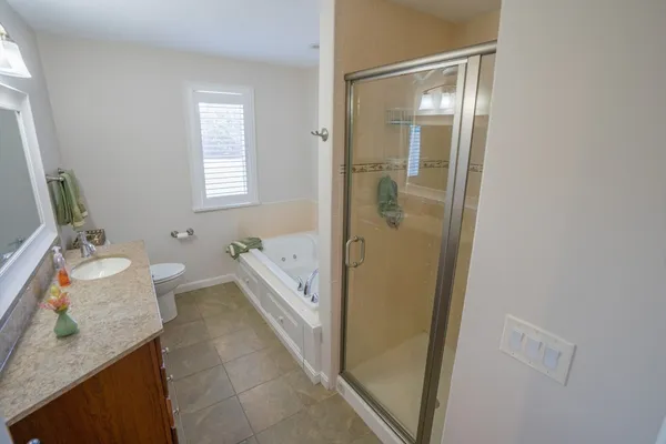a bathroom with a granite countertop sink mirror vanity and toilet
