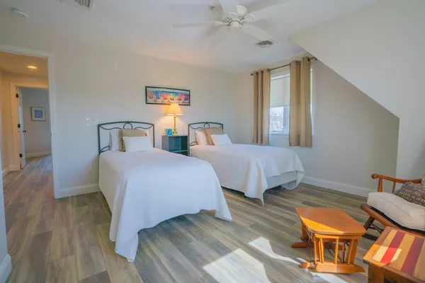 a bedroom with two beds and a chandelier