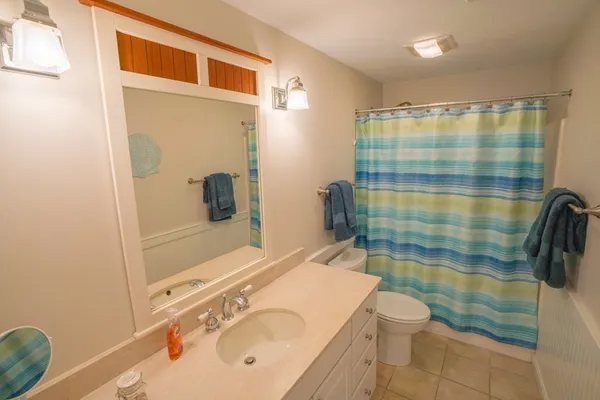 a bathroom with a sink and mirror with toilet