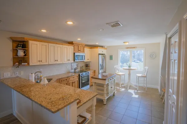a kitchen with a table chairs and a refrigerator