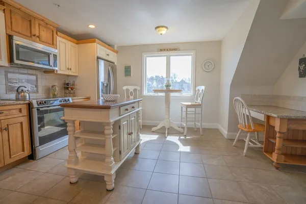 a kitchen with a table chairs refrigerator and cabinets