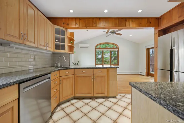 a kitchen with stainless steel appliances granite countertop a sink and a refrigerator