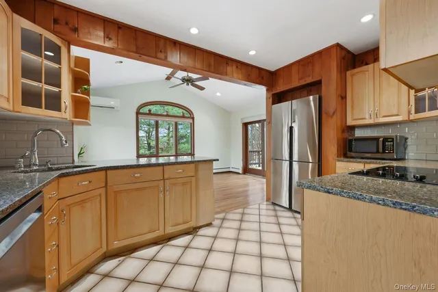 a kitchen with stainless steel appliances granite countertop a stove a sink and a refrigerator