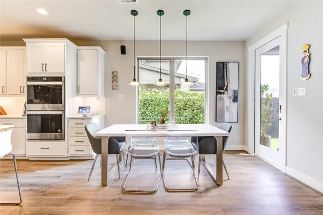 a dining room with furniture a chandelier and wooden floor