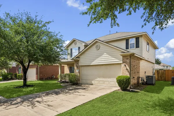 a front view of a house with a yard and trees