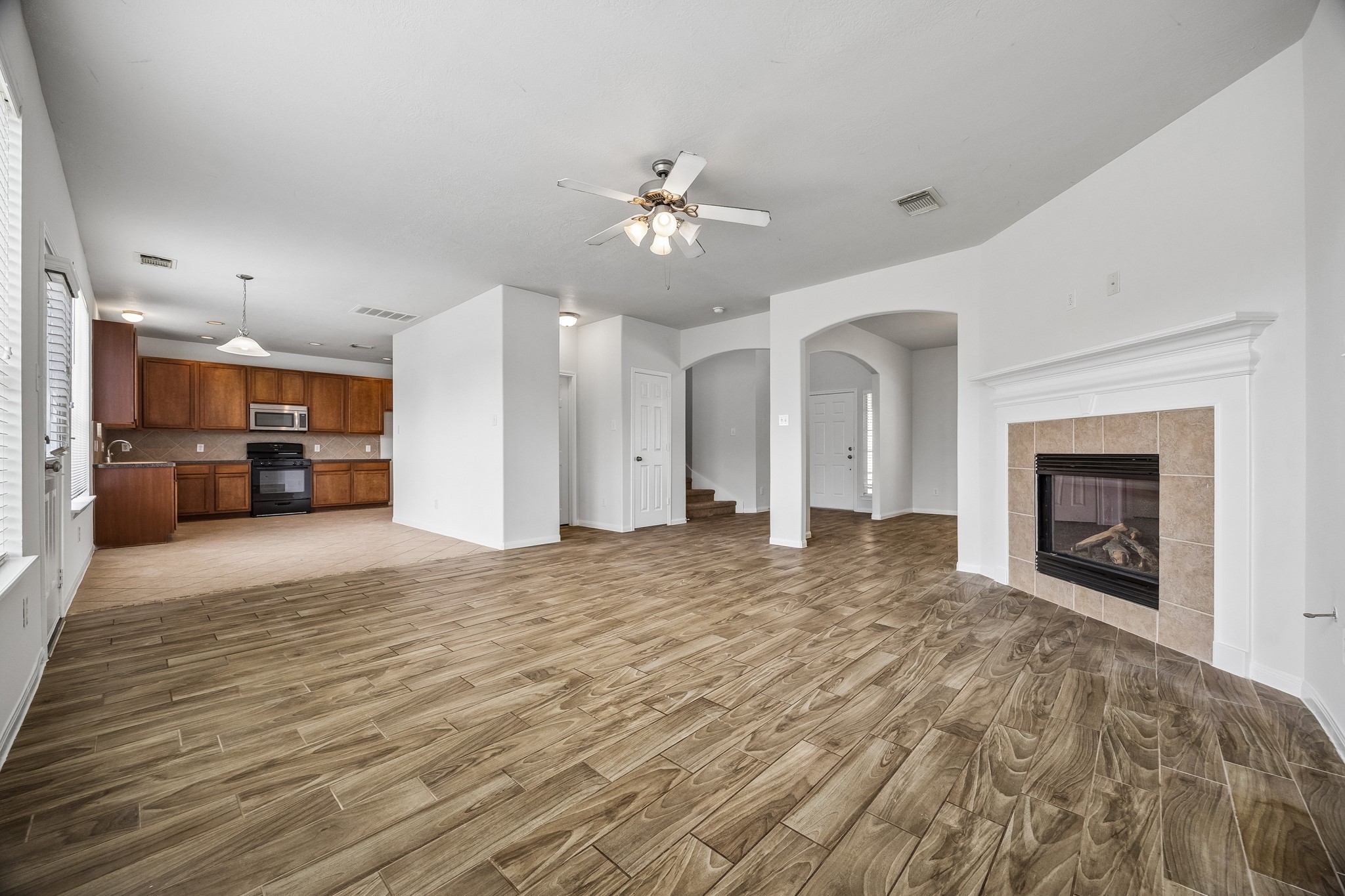 25211 Hazel Ranch Drive Katy, TX 77494 - Photo 2 of 10 a view of a livingroom with a fireplace a chandelier and wooden floor