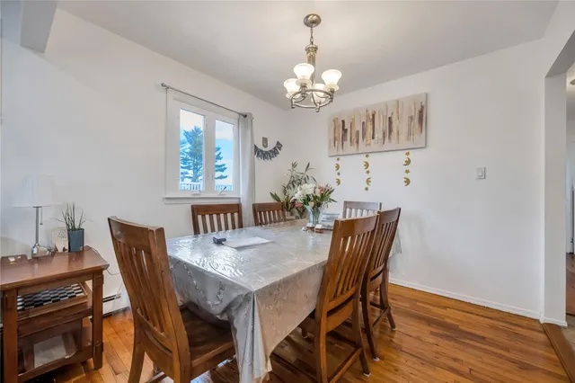 a view of a dining room with furniture a chandelier and wooden floor