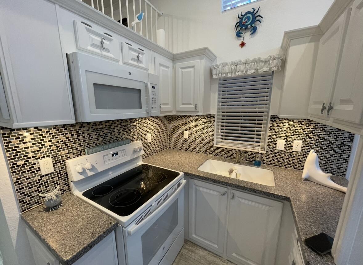 325 Calusa Street, Unit 55 Key Largo, FL 33037 - Photo 6 of 29 a kitchen with granite countertop a sink a stove and cabinets