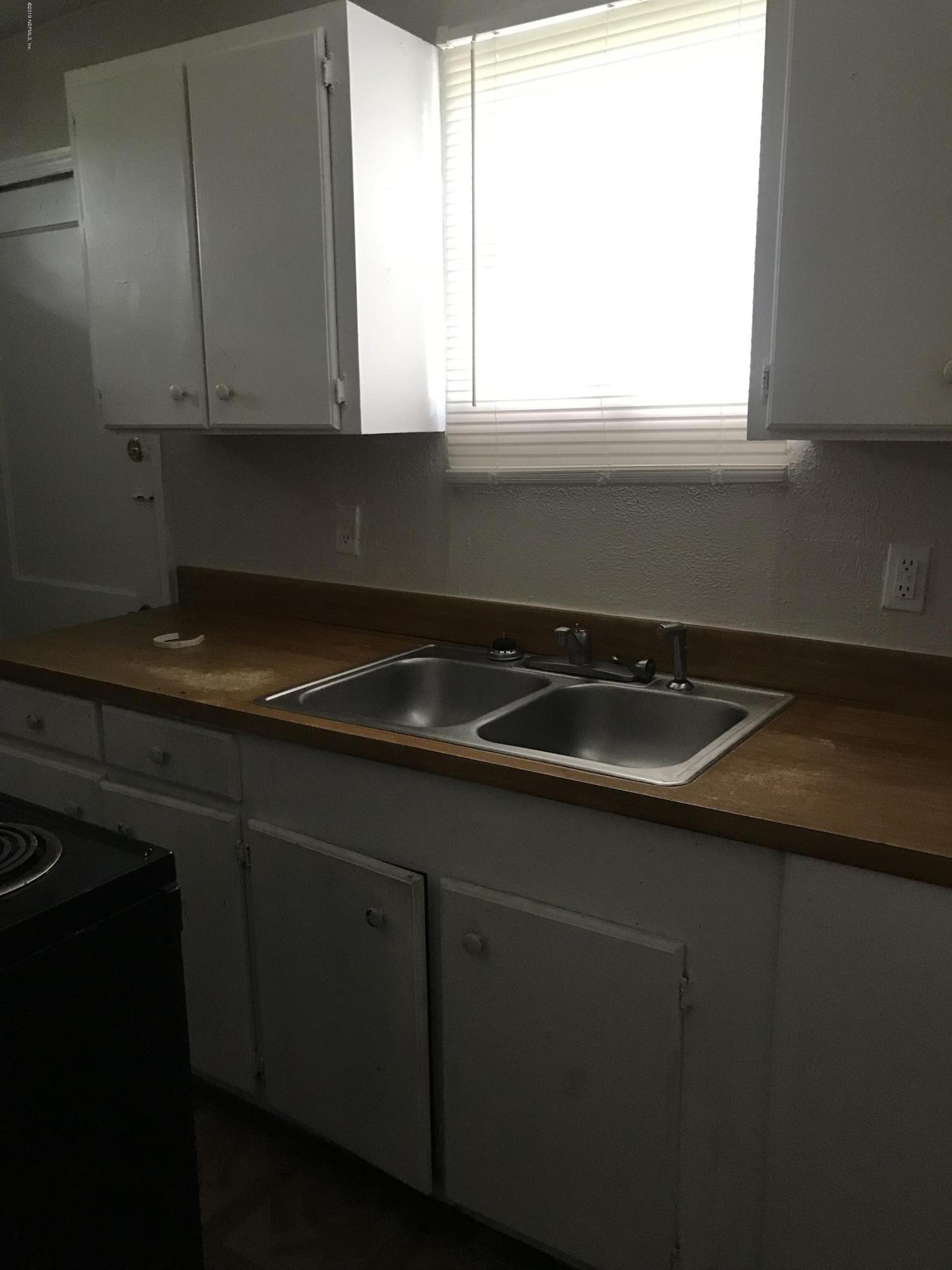 5606 Moncrief Road Jacksonville, FL 32209 - Photo 24 of 26 a kitchen with a sink a window and cabinets