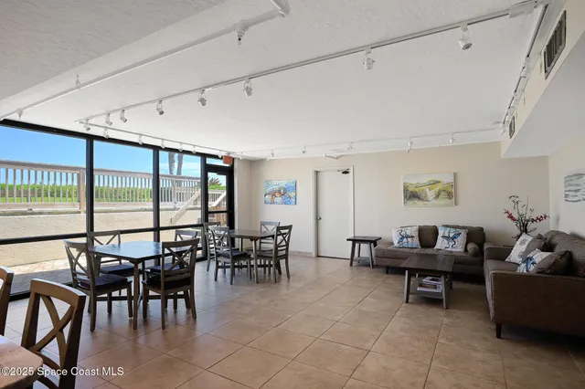 a kitchen with stainless steel appliances kitchen island granite countertop a table chairs sink and white cabinets