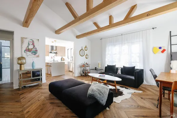 a living room with furniture a flat screen tv and a window