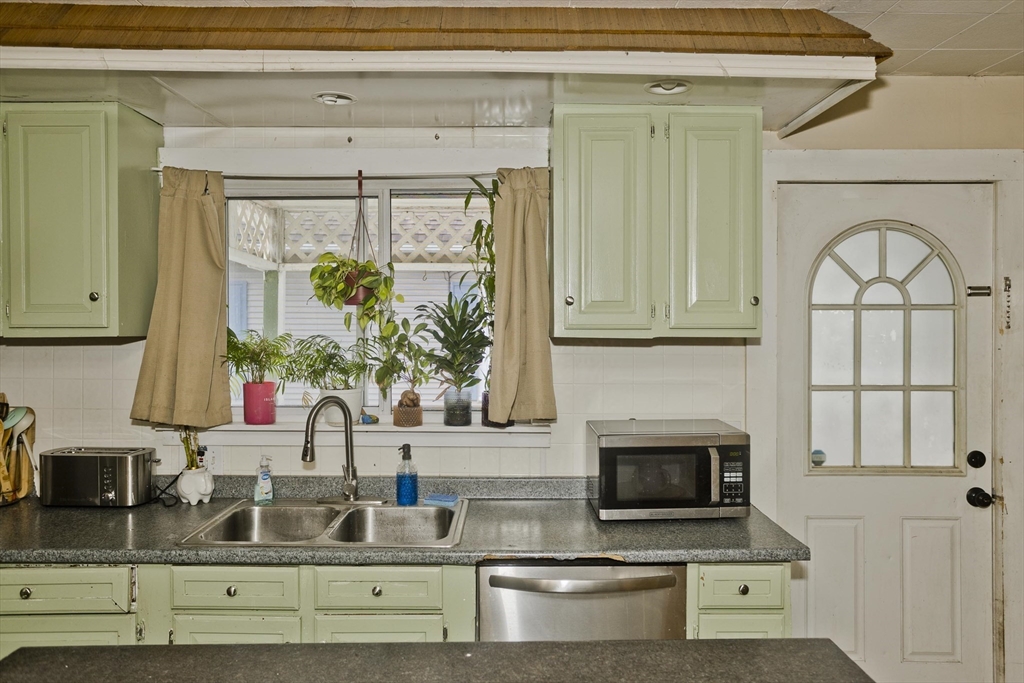 80 Stewart Street Chicopee, MA 01020 - Photo 14 of 37 a kitchen with sink a stove and white cabinets with wooden floor
