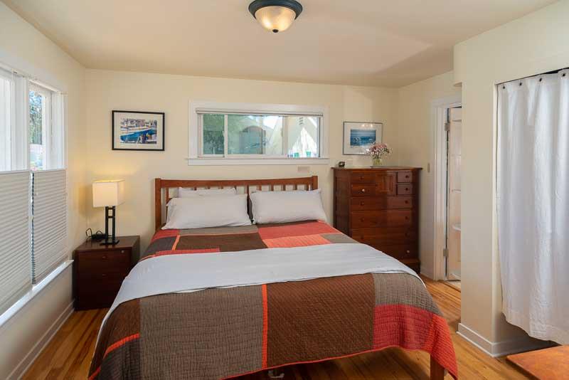 705 Oak Drive Capitola, CA 95010 - Photo 11 of 17 a bedroom with a bed and wooden floor