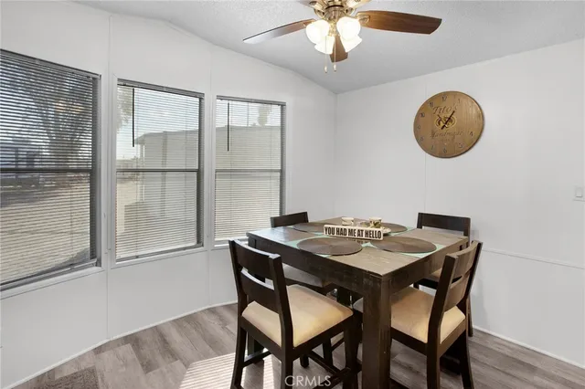 a view of a dining room with furniture and chandelier fan