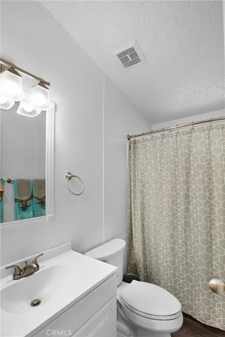 a bathroom with a sink a toilet and shower curtain