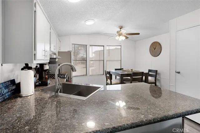 a kitchen with a sink a counter and chairs