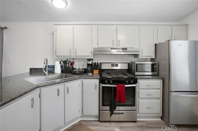 a kitchen with appliances a sink and cabinets