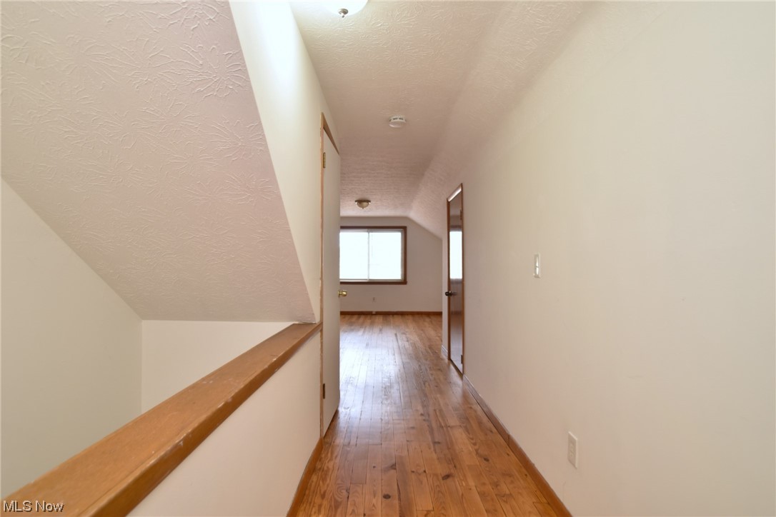 3681 Brinkmore Road Cleveland Heights, OH 44121 - Photo 19 of 27 Hall featuring a textured ceiling, vaulted ceiling, and light hardwood / wood-style flooring