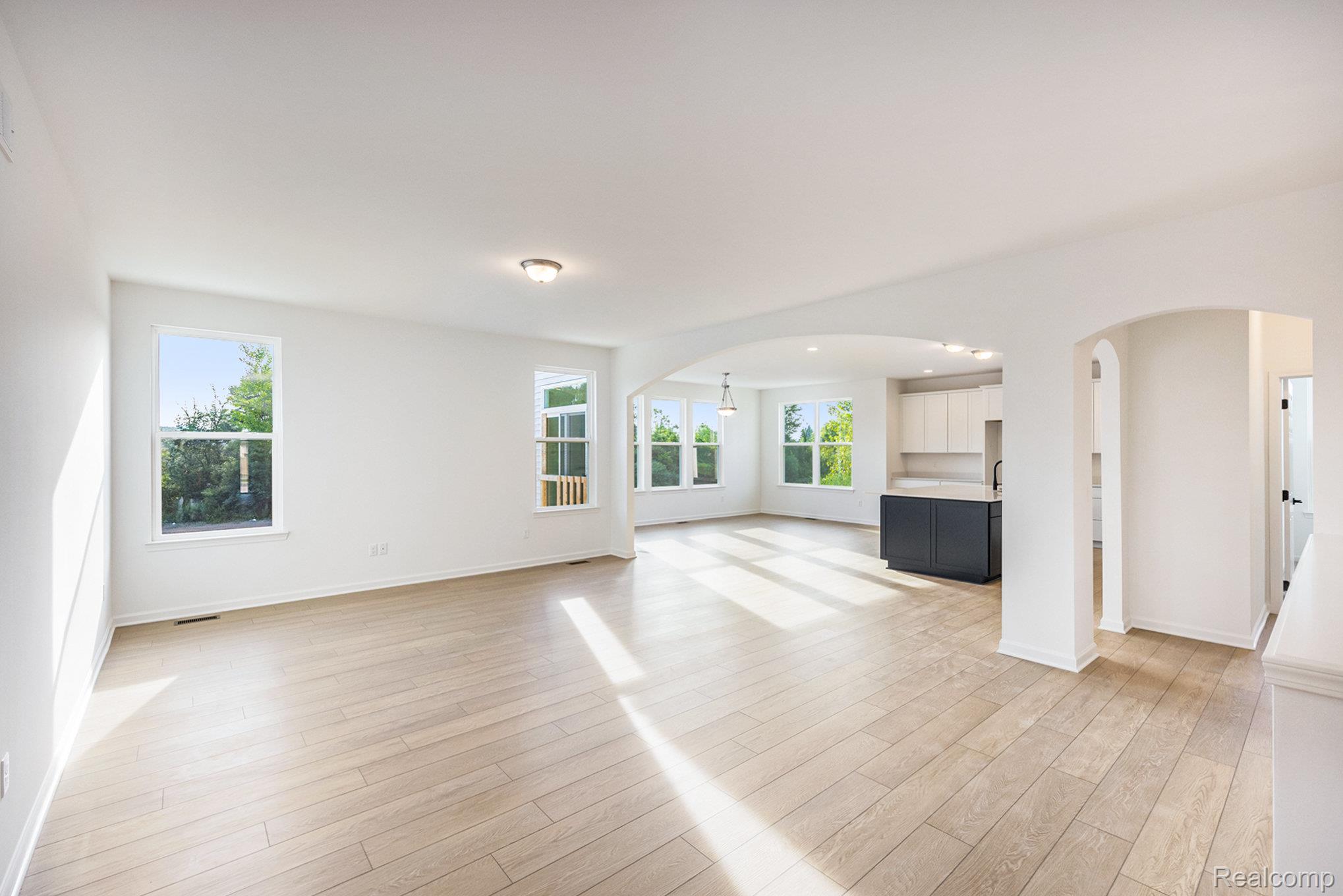 68788 Place Road New Haven, MI 48050 - Photo 3 of 29 Unfurnished living room with arched walkways and light wood-style floors