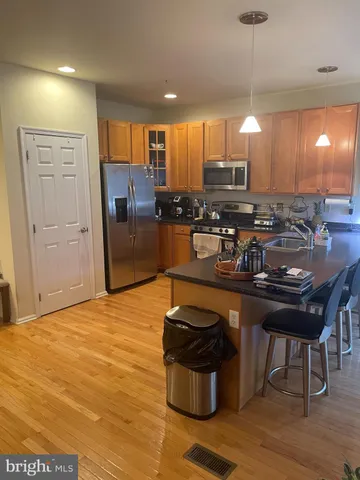 a kitchen with sink a refrigerator and chairs