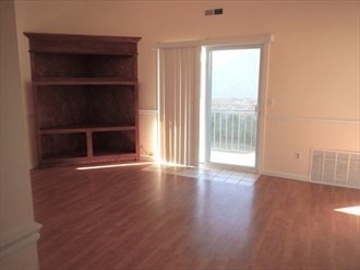 64 Tennis Plaza Road, Unit 2 Dracut, MA 01826 - Photo 3 of 11 an empty room with wooden floor and windows