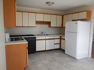 64 Tennis Plaza Road, Unit 2 Dracut, MA 01826 - Photo 5 of 11 a utility room with cabinets washer and dryer