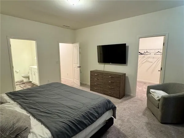 a bedroom with a bed a couch and a window