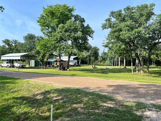 a view of green field with trees in the background