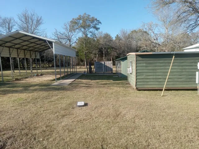 a backyard of a house with barbeque oven and table