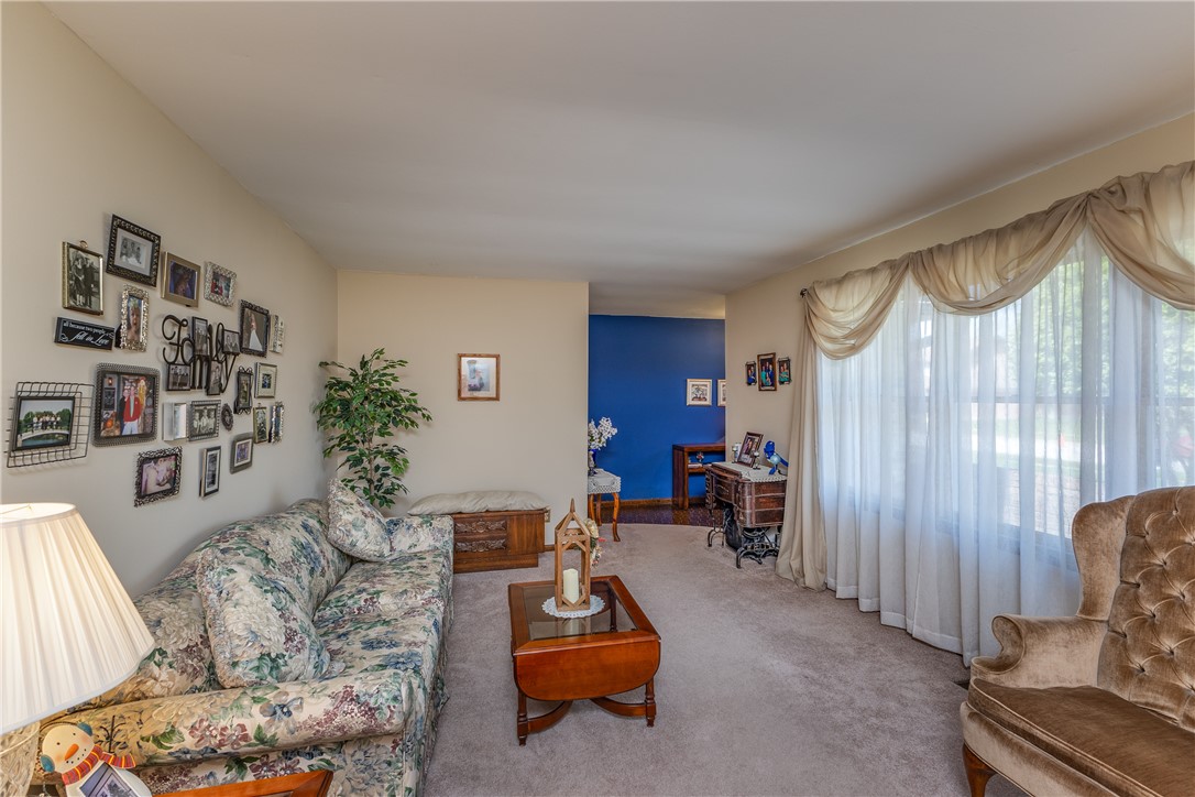 4210 Pleasanton Road Englewood, OH 45322 - Photo 7 of 34 This inviting living room features soft carpeting and ample natural light through a large window.