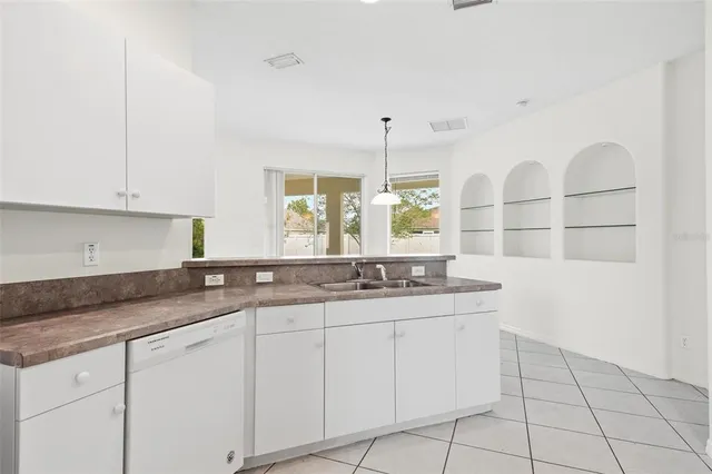 a kitchen with granite countertop white cabinets and a sink