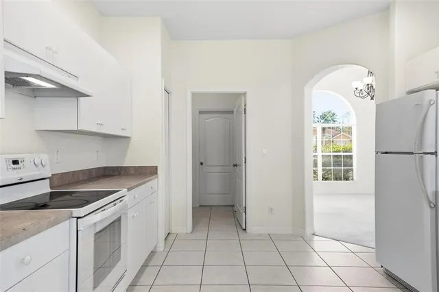 a kitchen with white cabinets and white appliances