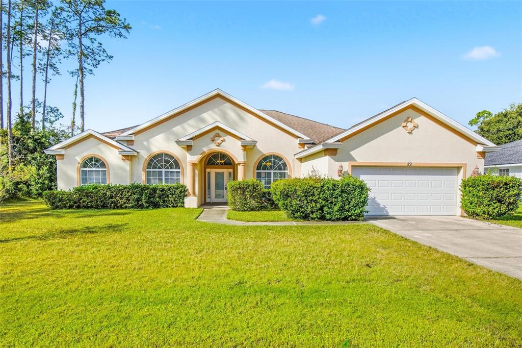 29 East Diamond Drive Palm Coast, FL 32164 - Photo 2 of 55 a view of a white house with a small yard and a large tree