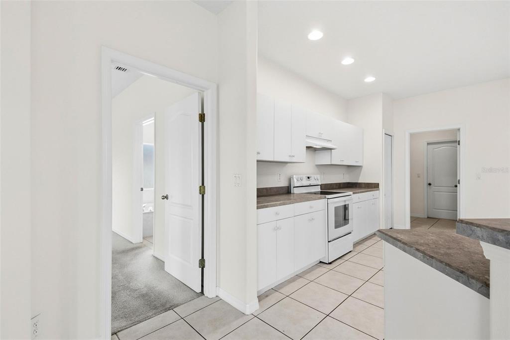 29 East Diamond Drive Palm Coast, FL 32164 - Photo 37 of 55 a kitchen with granite countertop white cabinets and white appliances