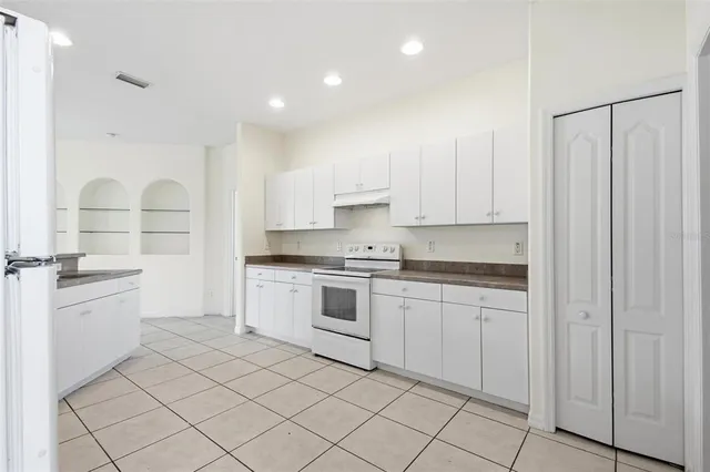 a kitchen with white cabinets and white appliances