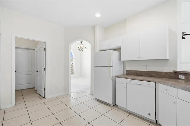 a kitchen with white cabinets and refrigerator