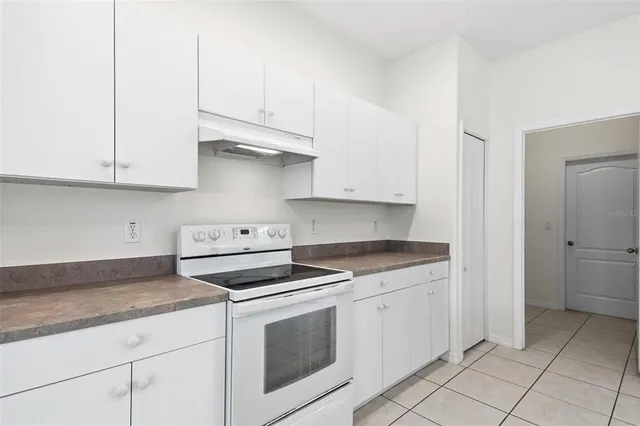 a kitchen with granite countertop white cabinets and white appliances