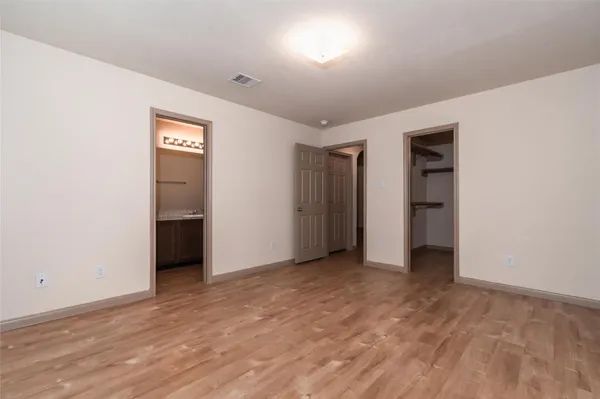 an empty room with closet and a bathroom