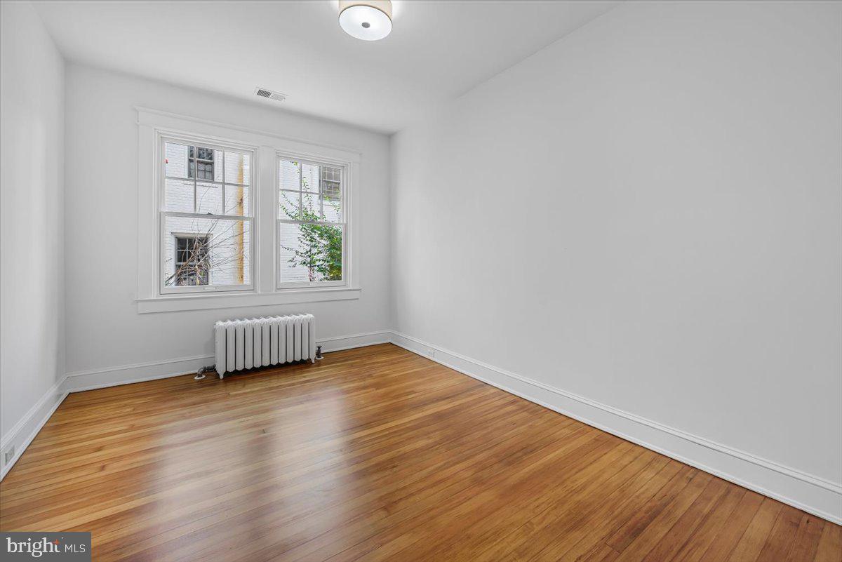4937 Brandywine Street Northwest Washington, DC 20016 - Photo 21 of 53 an empty room with wooden floor and windows