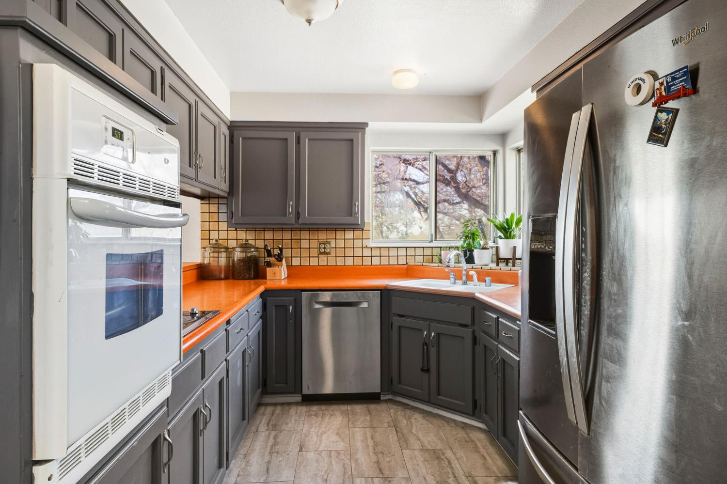 11172 North Ponderosa Way Rough and Ready, CA 95975 - Photo 16 of 47 a kitchen with stainless steel appliances granite countertop a refrigerator a sink dishwasher a stove with wooden cabinets and floor