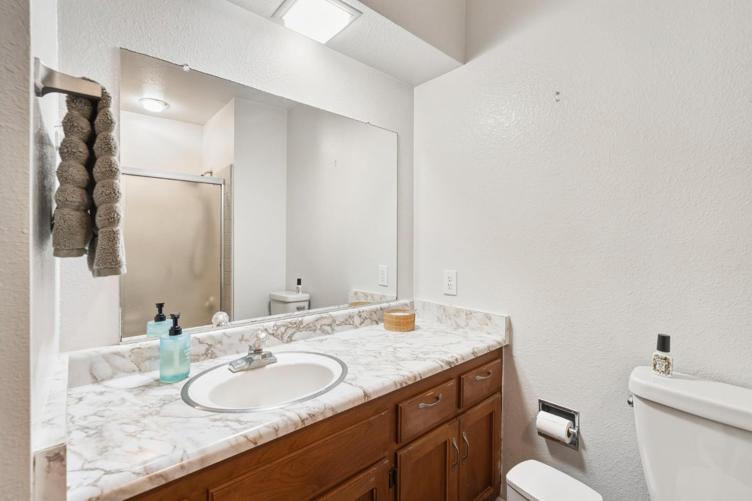 11172 North Ponderosa Way Rough and Ready, CA 95975 - Photo 26 of 47 a bathroom with a granite countertop sink and a mirror with toilet