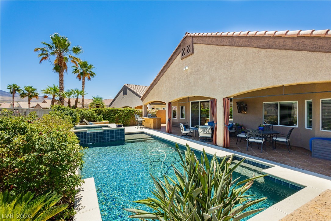 2256 Dogwood Ranch Avenue Henderson, NV 89052 - Photo 46 of 51 An inviting backyard oasis presents a refreshing pool with a connected spa and a generous covered patio, perfect for entertaining.