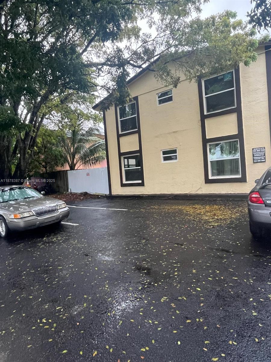 7490 Southwest 10th Court, Unit 14 North Lauderdale, FL 33068 - Photo 2 of 7 a view of a backyard with table and chairs and wooden fence
