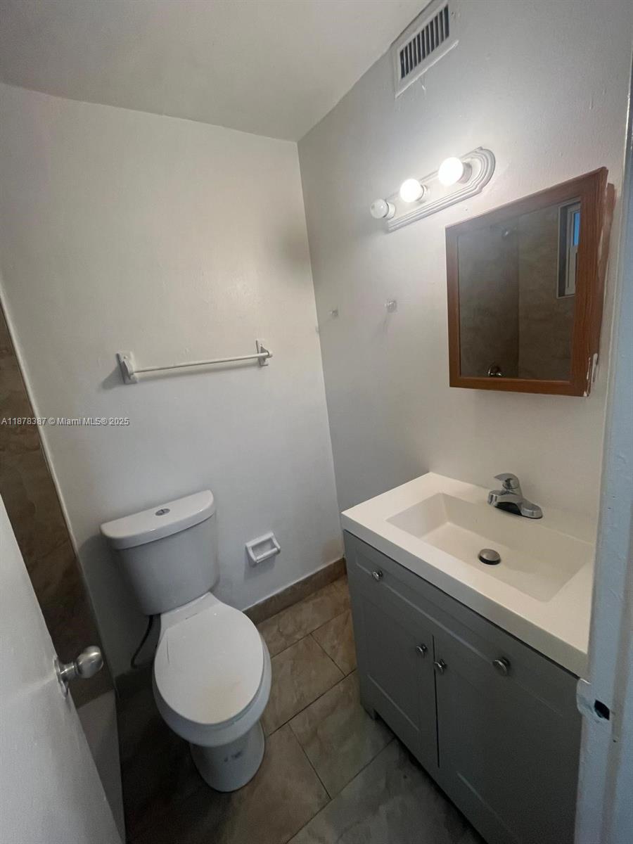 7490 Southwest 10th Court, Unit 14 North Lauderdale, FL 33068 - Photo 3 of 7 a bathroom with a toilet sink and mirror